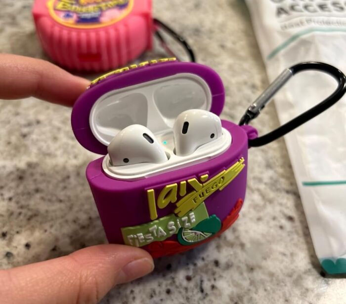 Weirdest gift idea: AirPods in a quirky, purple snack-themed case with a black carabiner clip.