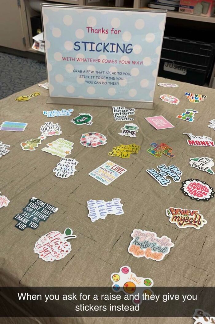 Stickers on a table with a sign thanking employees; an example of infuriating company gifts instead of bonuses.