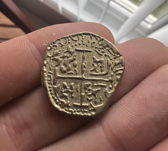 Ancient coin with intricate design held between fingers, appealing to numismatists.