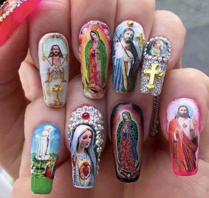 Bizarre nail art featuring religious images and decorative crosses.