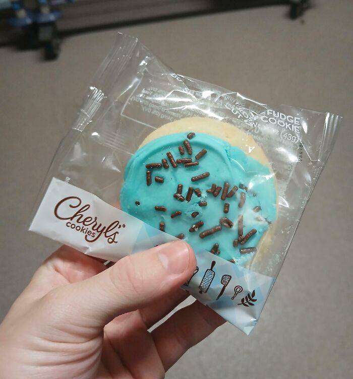 A packaged cookie with blue icing and chocolate sprinkles, representing company gifts bonuses.