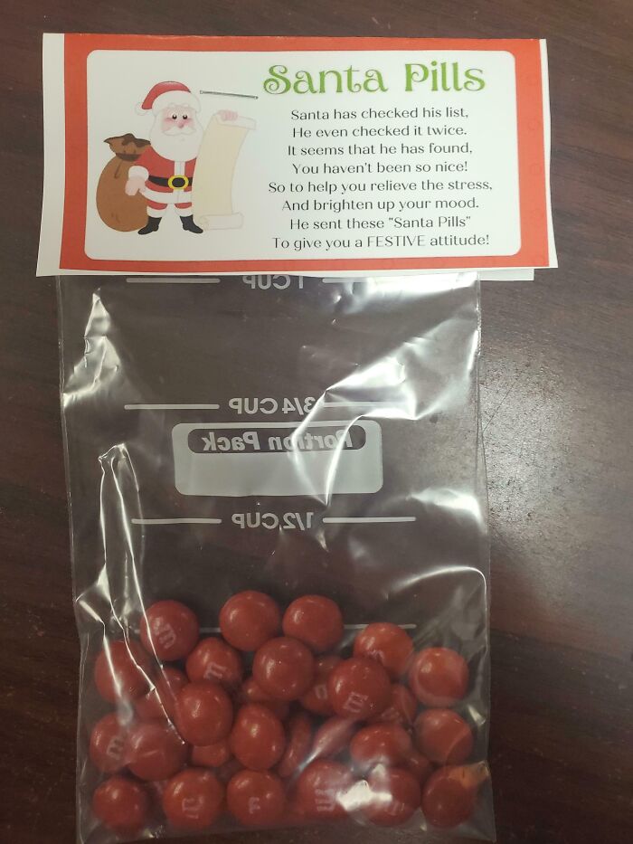 Bag of red candies labeled "Santa Pills" as humorous company gifts or bonuses.