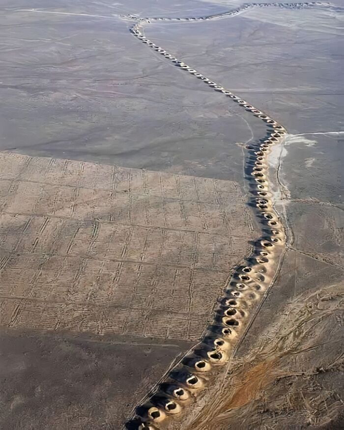 Aerial view of fascinating ancient aqueduct in desert landscape.