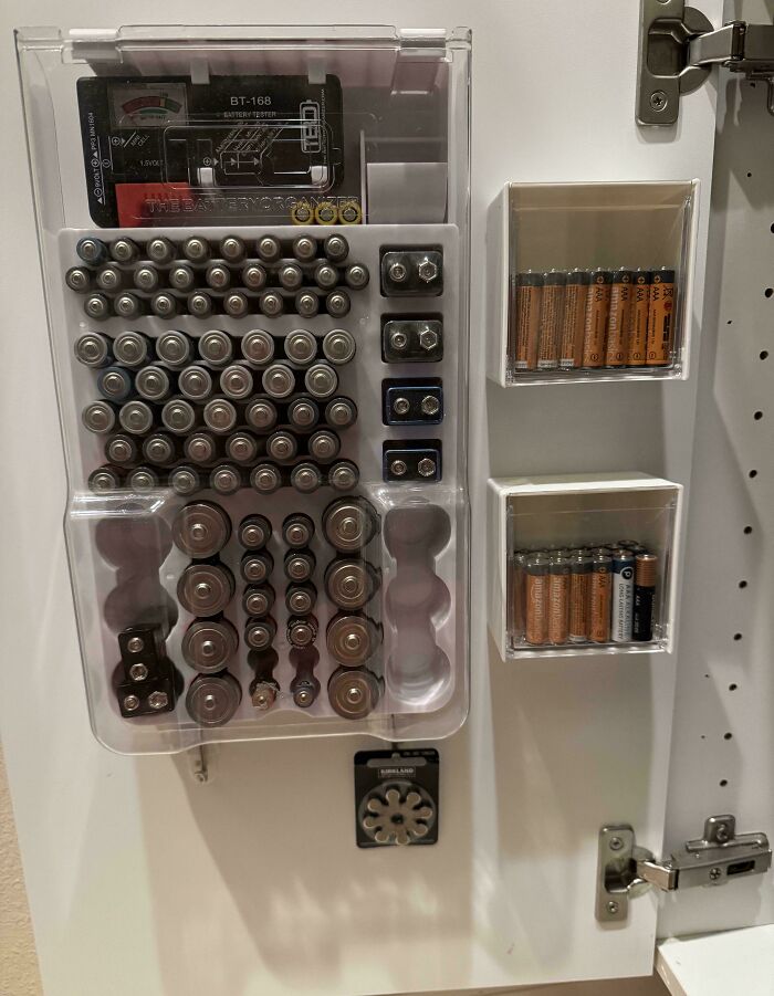 Neatly organized battery storage on a cabinet door, showcasing next-level organization skills.