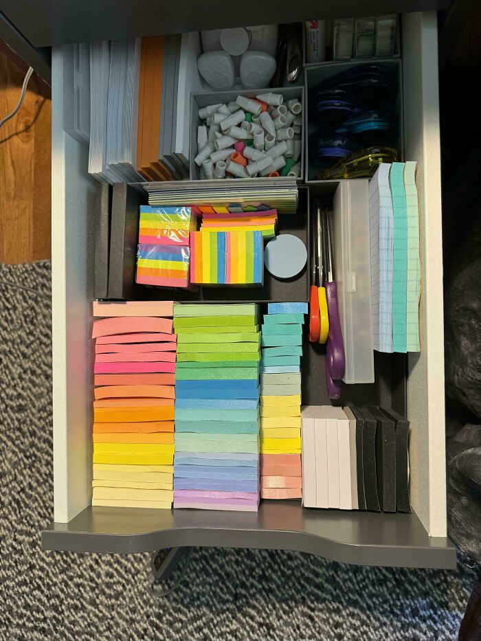 Neatly organized drawer with colorful sticky notes and office supplies, showcasing next-level organization.