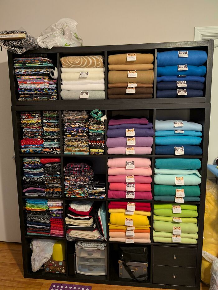 Neat results of next-level organization: a well-organized shelf with folded colorful fabrics in cubbies.