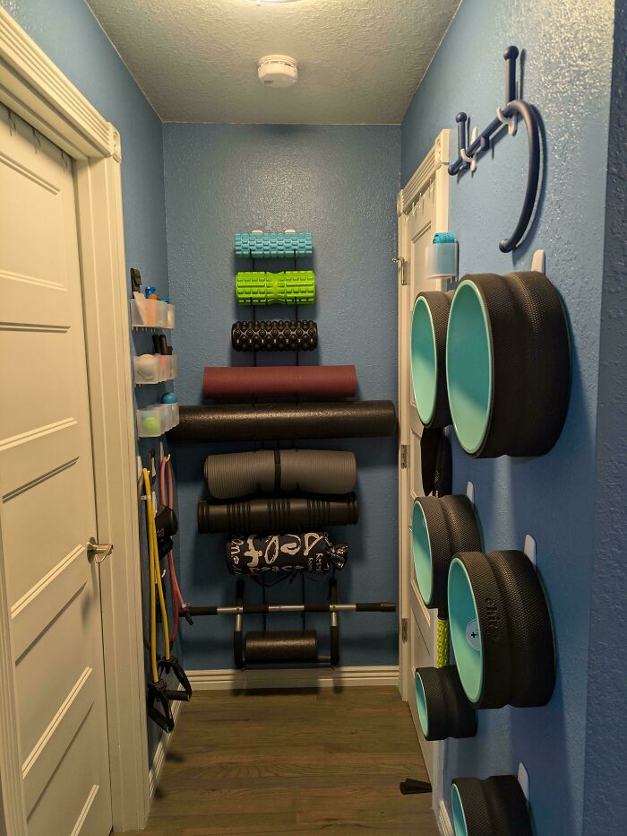 Neatly organized exercise equipment in a small blue room showcasing next-level organization.