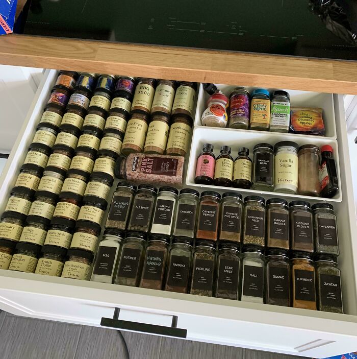 Neatly organized spice drawer with labeled jars showcasing next-level organization.