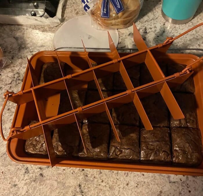 Brownies in a pan with a divider, showcasing a cool product for perfectly cut pieces.