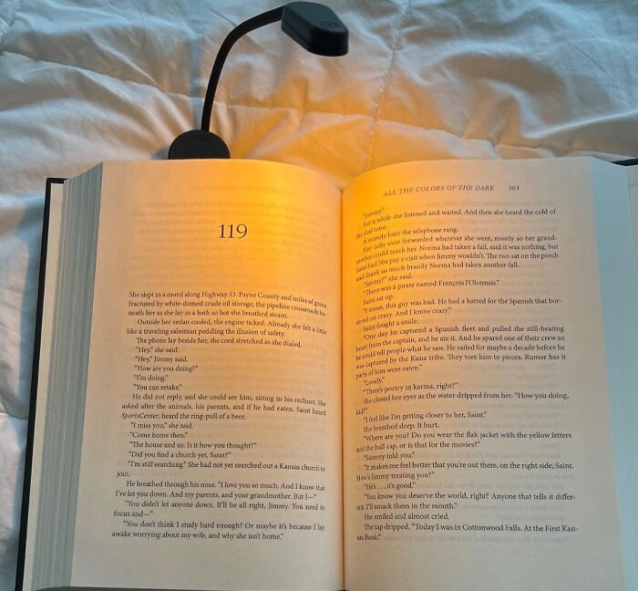 Open book with text illuminated by a reading light, perfect for Valentine's Day finds.