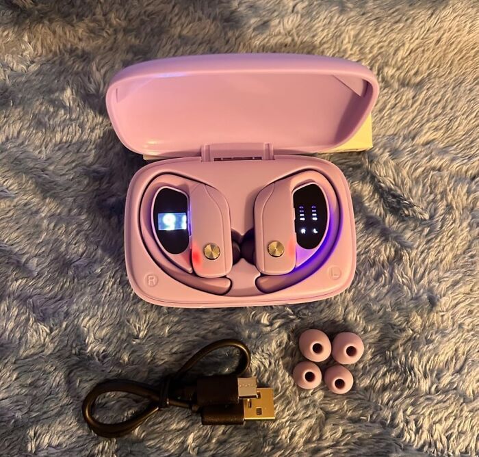 Purple wireless earbuds in open case with extra ear tips and charging cable, ideal Valentines Day finds.