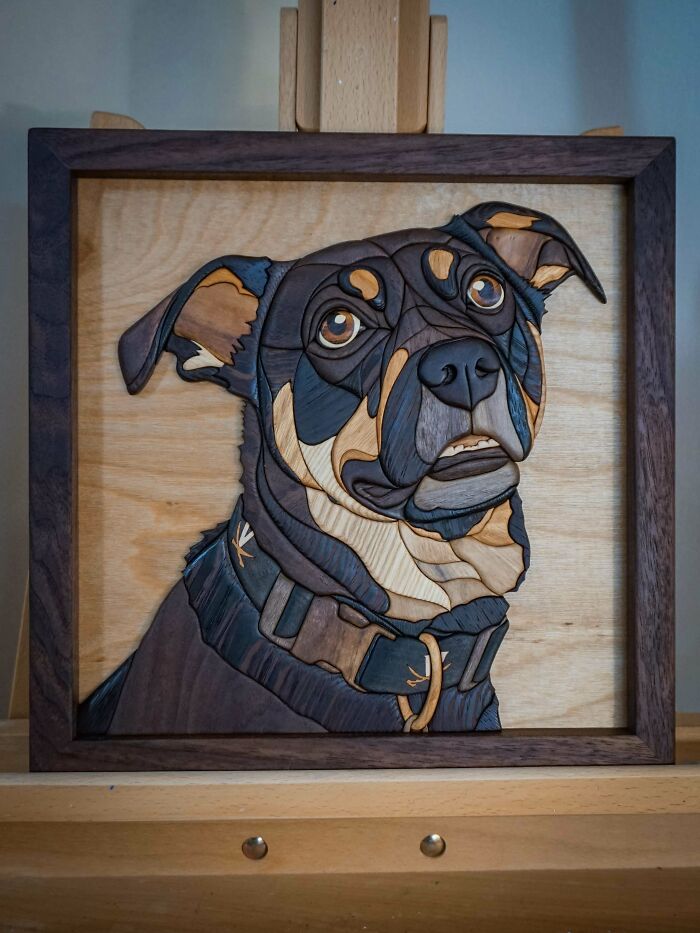 Woodworking project of a detailed dog portrait in a wooden frame, showcasing intricate craftsmanship.