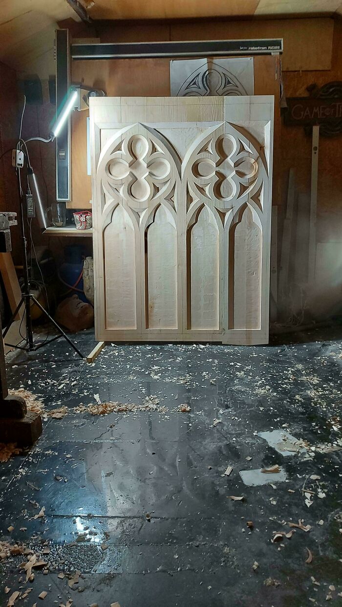 Intricate woodworking project in workshop showcasing detailed wood carving under bright light.