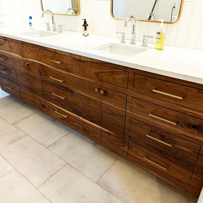 Elegant woodworking project featuring a wooden bathroom vanity with brass handles and twin sinks.