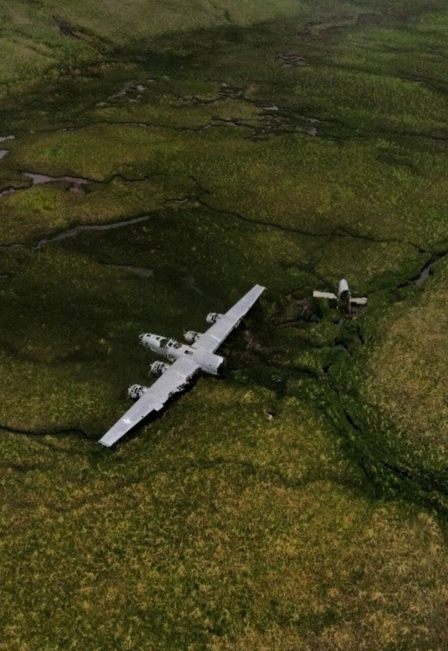 Aerial view of an abandoned airplane on a grassy field, discovered on Google Earth.