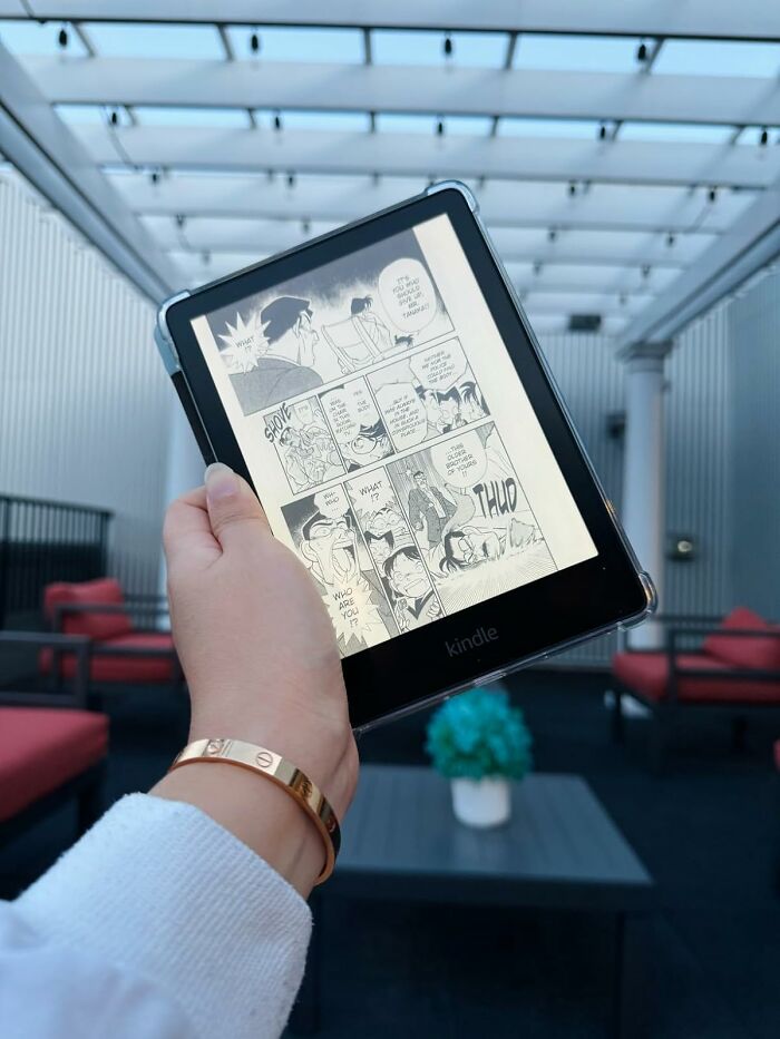 Reading a manga on a Kindle outdoors, showcasing new hobbies in 2025.