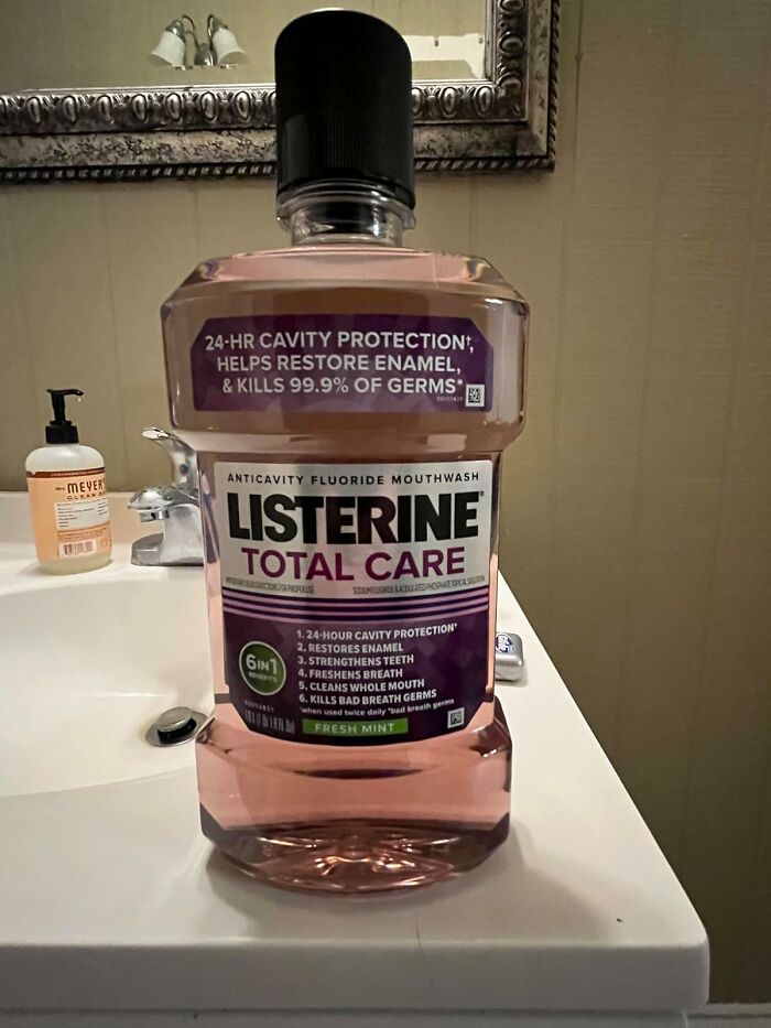 Bottle of Listerine Total Care mouthwash on a bathroom sink, part of personal care products.