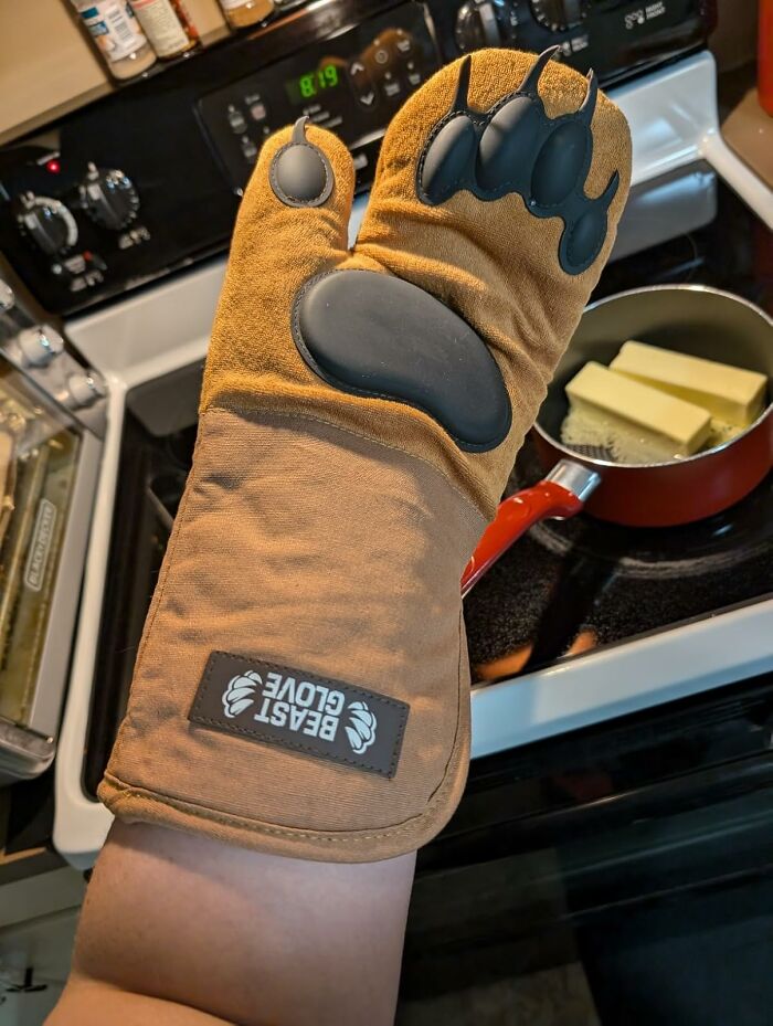 Weird gift: a bear paw-shaped oven mitt labeled "Beast Glove" in use near a stove.