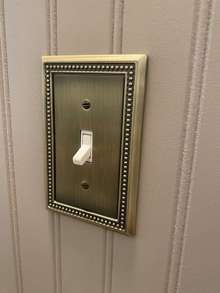 Decorative light switch on textured wall, modernizing apartment decor.