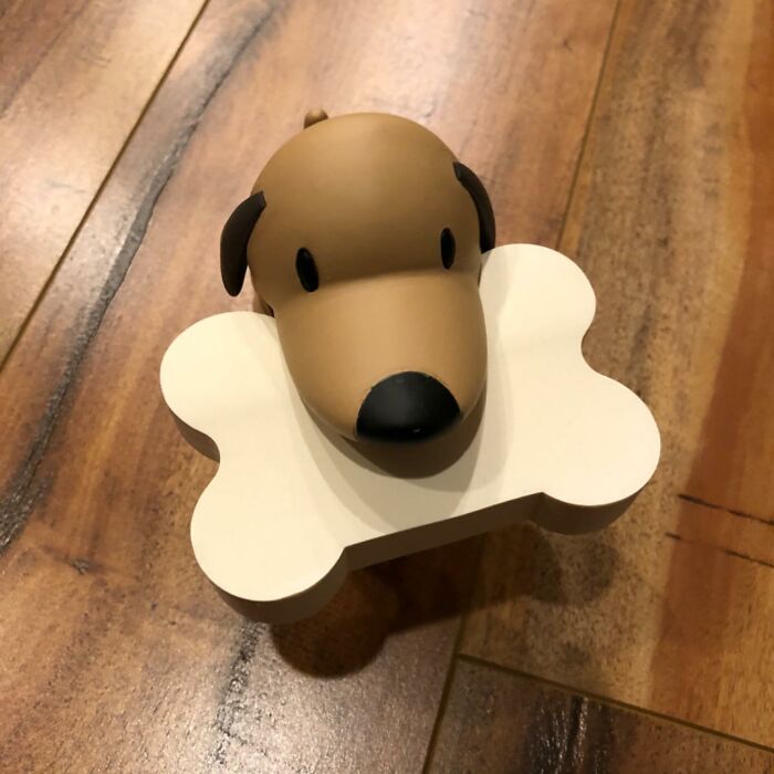 Dog-themed office supply on wooden desk, featuring a bone-shaped memo holder.