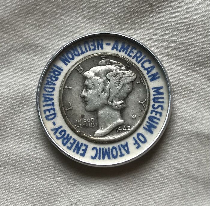 Historic coin from 1942 displayed with text from the American Museum of Atomic Energy, valuable for numismatists.