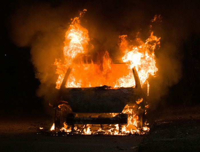 Burning car engulfed in flames at night, illustrating a true crime cold case scene.