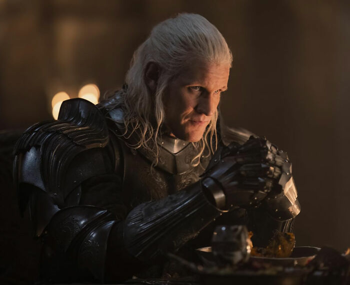 Actor in medieval armor, with long white hair, embodying a pigeonholed role in a dimly lit setting.