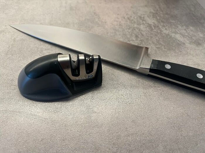 Knife sharpening tool on a counter, highlighting essentials to get better at cooking.