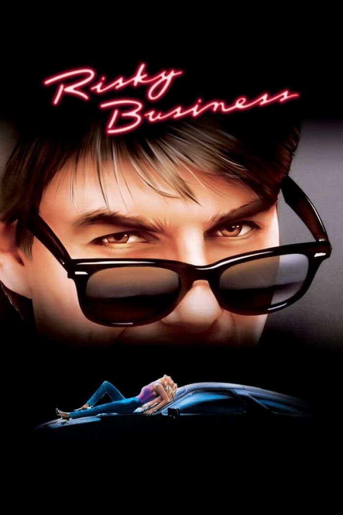 Close-up of a character's eyes behind sunglasses, with the text "Risky Business" above and a person on a car hood below.