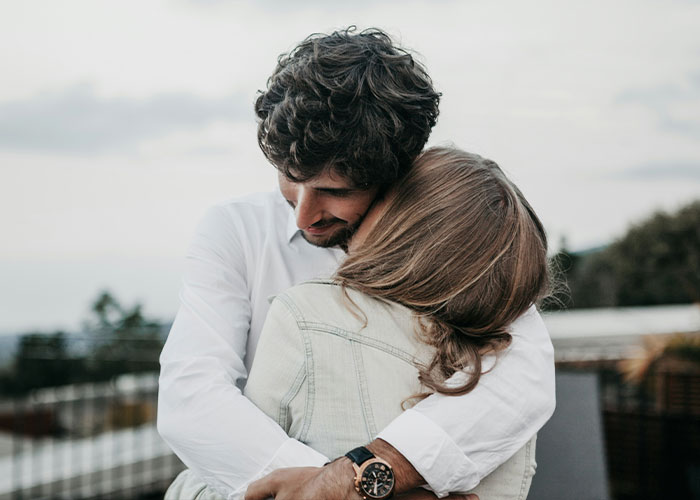 A couple embracing outdoors, capturing a tender moment of support and comfort between a Canadian woman and her partner.