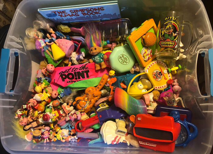 Box filled with colorful 80s nostalgia items like toys, a View-Master, and a Simpsons book.