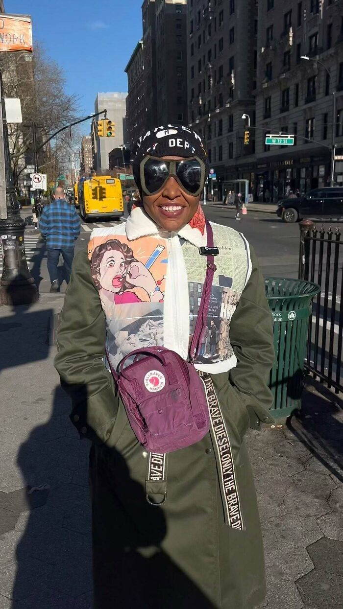 NYC local in a unique jacket, sunglasses, and cap, holding a purple backpack, showcasing experimental fashion.