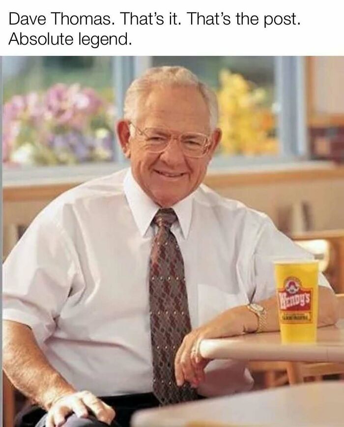 Elderly man smiling, seated at a table with a fast-food cup, evoking nostalgic memories.