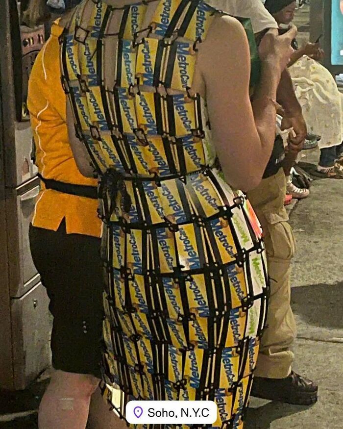 NYC local wearing an experimental dress made from yellow caution tape, showcasing bold fashion in Soho, N.Y.C.