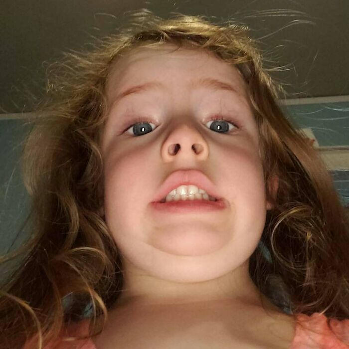 A child making a funny face in a selfie, capturing a humorous moment for funny-camera-roll-finds.