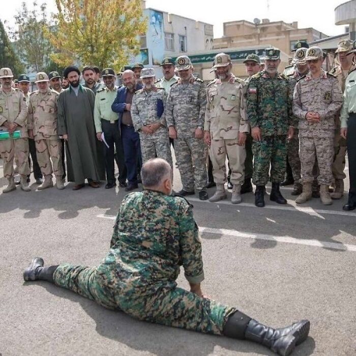 Officer performs a split in front of a group, showcasing bizarre scene from eclectic Instagram page.