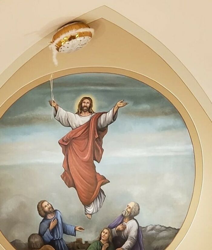 Bizarre photo of a religious painting with a balloon stuck on the ceiling, creating an eclectic visual effect.