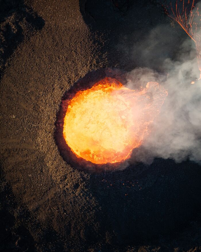 Aerial view of a glowing volcanic crater, capturing the untamed beauty of nature.