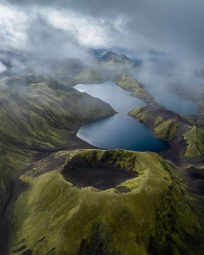 Drone view of lush green landscape and volcanic crater, showcasing nature photography by Jeroen Van Nieuwenhove.