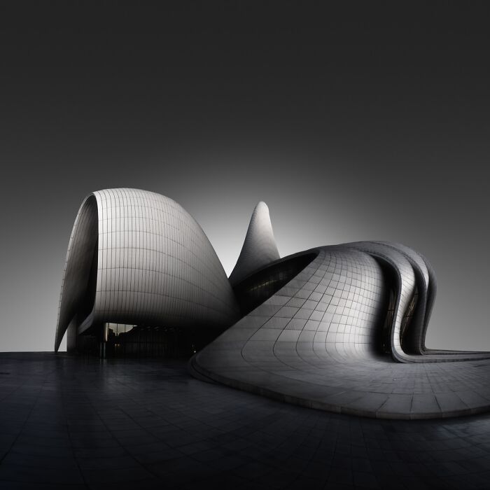 Futuristic architecture showcased at Tokyo International Foto Awards, featuring smooth, flowing curves against a dark sky.