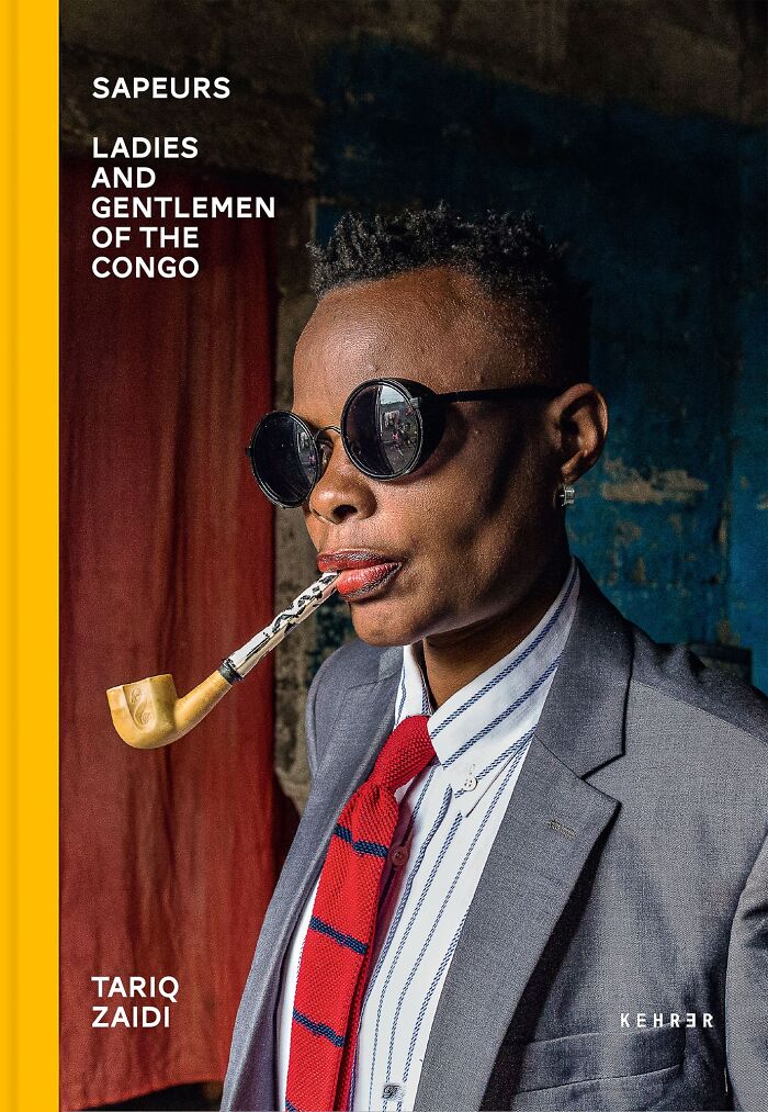 Person wearing sunglasses and a stylish suit with a pipe, featured in Tokyo International Foto Awards 2024.