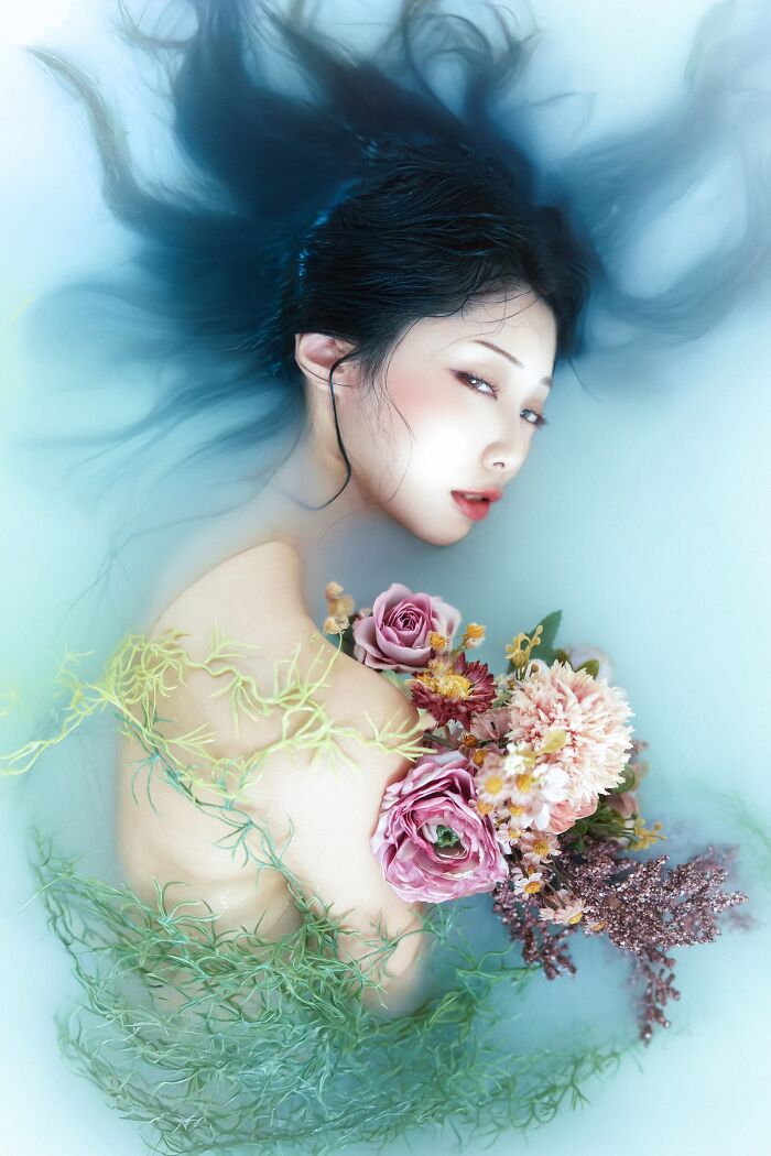 Portrait of a woman in water with flowers, showcasing artistic photography for Tokyo International Foto Awards.