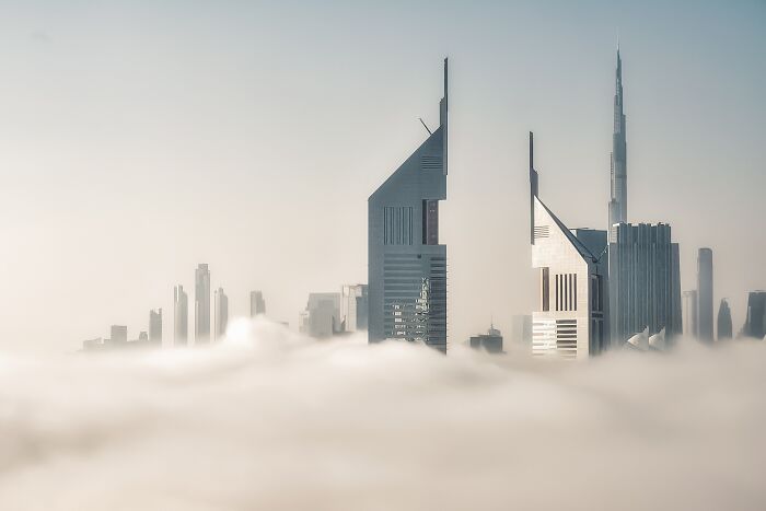 Modern skyscrapers emerging through morning fog, captured for Tokyo International Foto Awards.