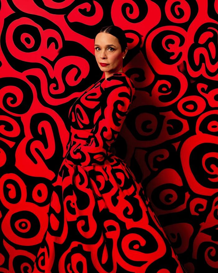 Woman in a red and black swirling pattern dress at Tokyo International Foto Awards.