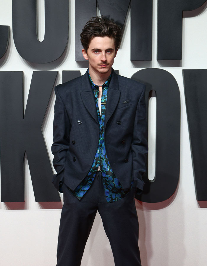 Young actor in a dark suit and floral shirt at an event, related to Oscar nominations breaking records.