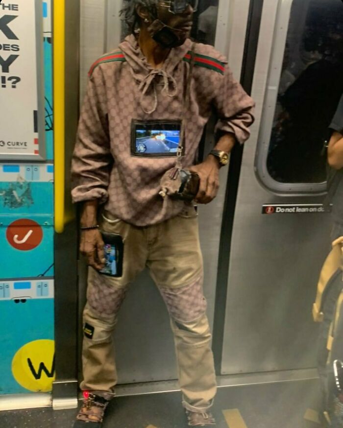 NYC local wearing unique fashion with decorated hoodie and trousers on the subway.