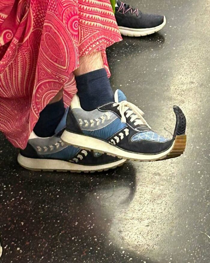 NYC local wearing unique sneakers with curled toes and a pink patterned skirt, showcasing experimental fashion.