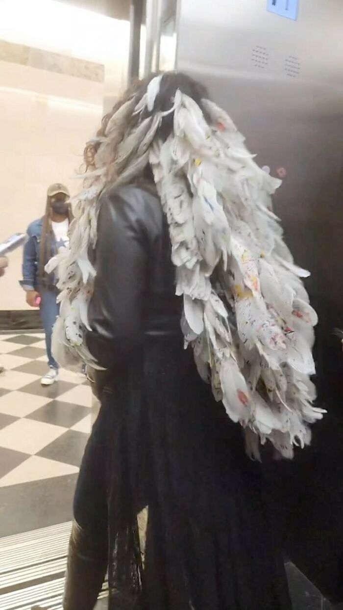 NYC local wearing a dramatic feathered outfit paired with a leather jacket, showcasing experimental fashion style.