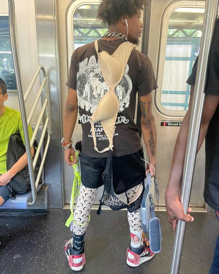 A NYC local wearing eclectic fashion with leggings, layered tops, and accessories on a subway.