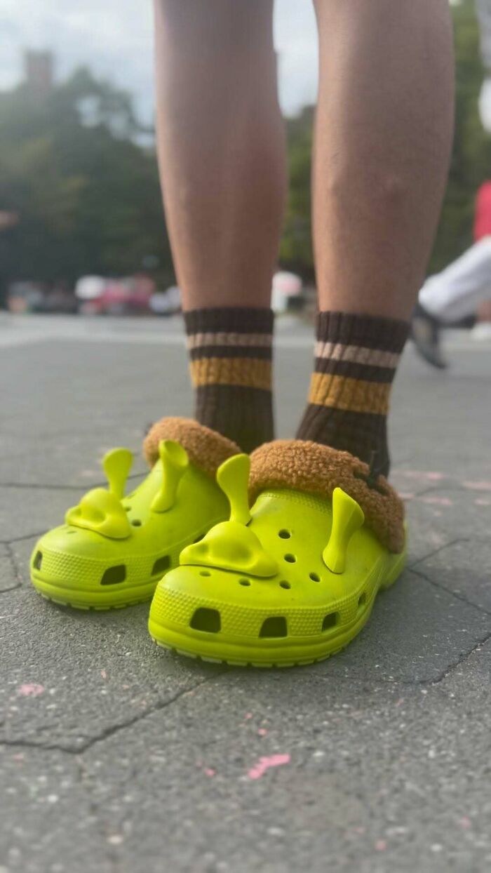 NYC local wearing bright green Crocs and striped socks, showcasing bold fashion experimentation on city streets.